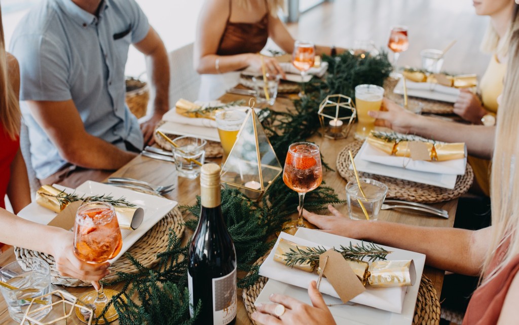 Christmas Day lunch table setup with bonbons, champagne and seasonal decor.